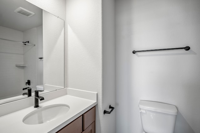 bathroom with vanity, toilet, and a shower