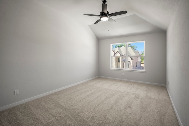 unfurnished room with light carpet, ceiling fan, and vaulted ceiling