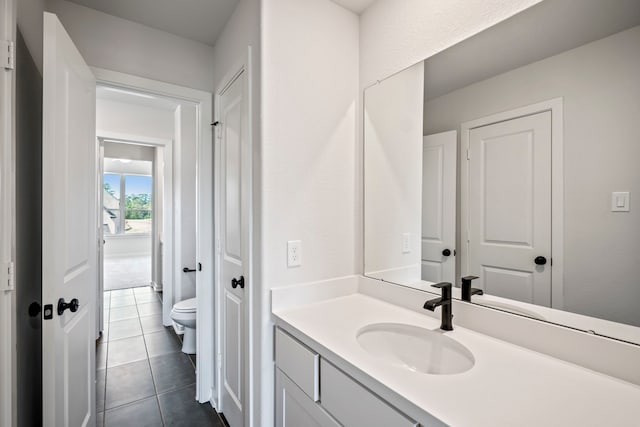 bathroom featuring vanity, toilet, and tile patterned flooring