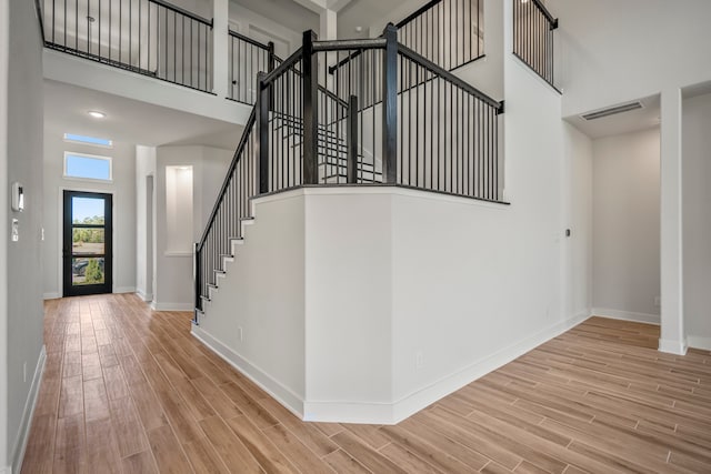 interior space with a towering ceiling and hardwood / wood-style floors