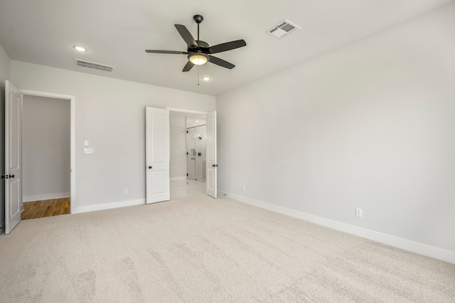 unfurnished bedroom featuring light colored carpet and ceiling fan