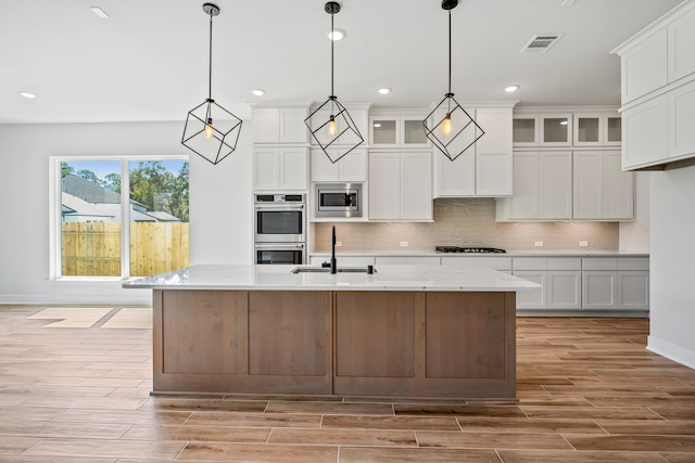 kitchen with white cabinetry, stainless steel appliances, and hanging light fixtures