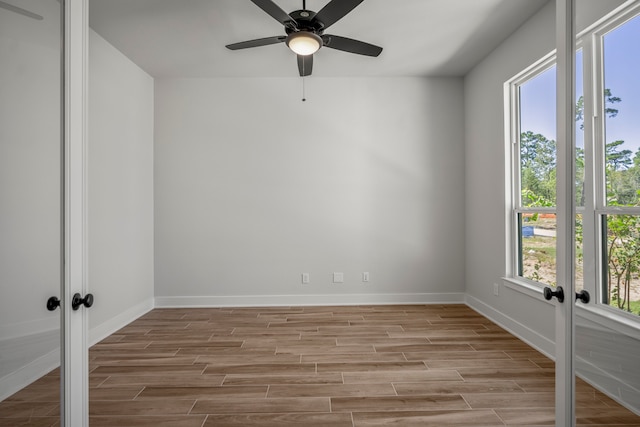 spare room with light hardwood / wood-style flooring, french doors, a healthy amount of sunlight, and ceiling fan