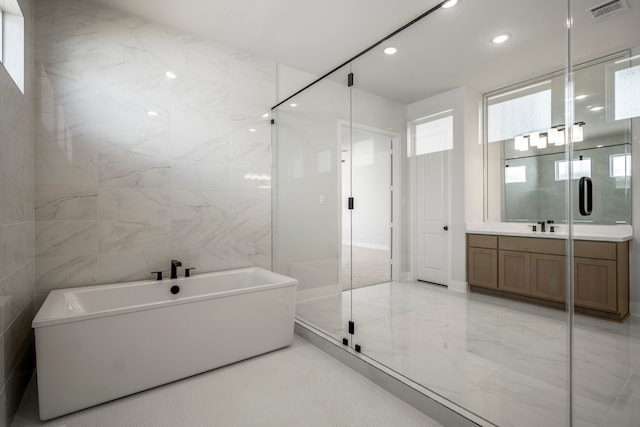 bathroom featuring vanity, a healthy amount of sunlight, tile walls, and separate shower and tub