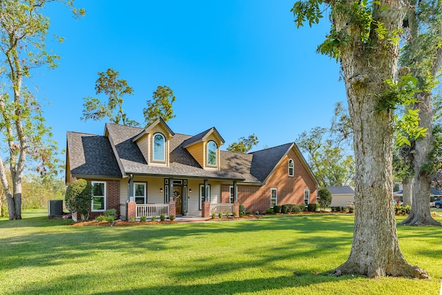 new england style home with a front yard, covered porch, and central AC unit