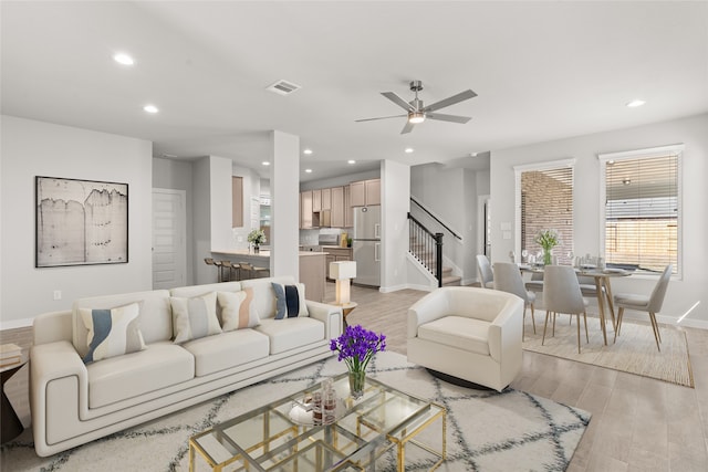 living room with ceiling fan and light wood-type flooring