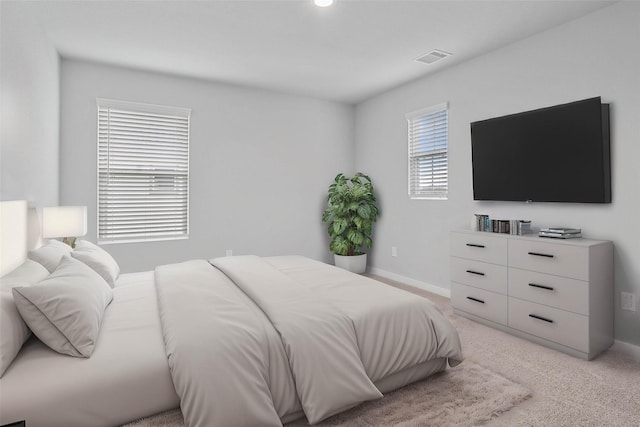 bedroom with visible vents, light carpet, and baseboards