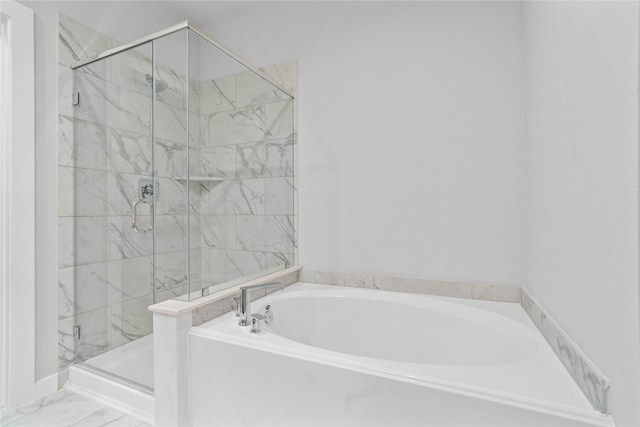 bathroom with a stall shower, marble finish floor, and a bath