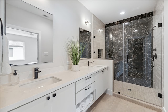 bathroom featuring vanity, a shower with shower door, and tile patterned floors