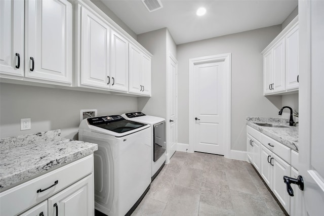 laundry room featuring cabinets, washer and clothes dryer, and sink