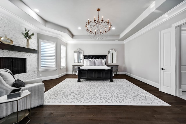 bedroom featuring dark hardwood / wood-style flooring, an inviting chandelier, a raised ceiling, and ornamental molding