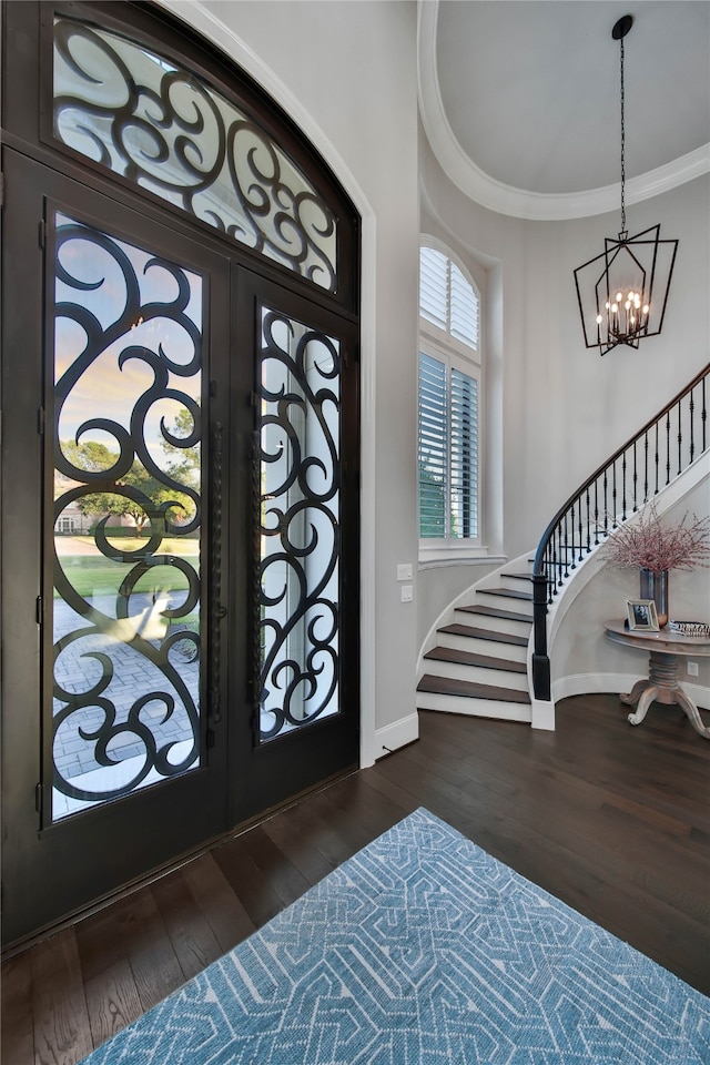 entryway with dark hardwood / wood-style flooring, a chandelier, french doors, and ornamental molding