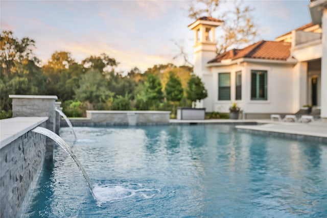 pool at dusk with pool water feature