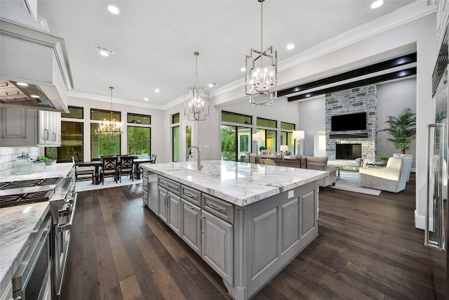 kitchen featuring gray cabinetry, a fireplace, hanging light fixtures, and dark wood-type flooring