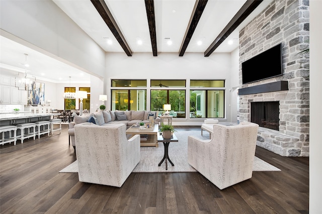 living room with a fireplace, dark hardwood / wood-style flooring, a high ceiling, and an inviting chandelier