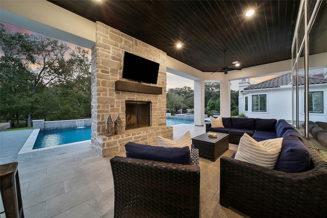 view of patio / terrace with an outdoor living space with a fireplace, ceiling fan, and pool water feature