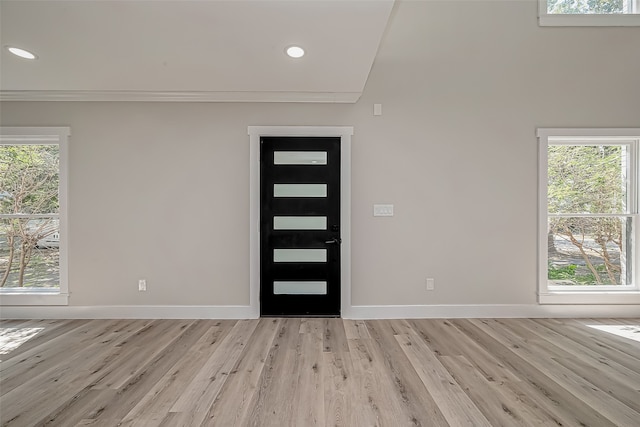 foyer featuring light hardwood / wood-style floors and crown molding