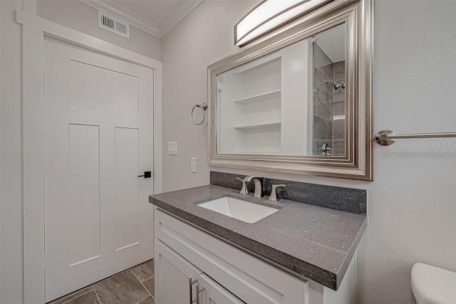 bathroom featuring vanity, ornamental molding, toilet, and a shower