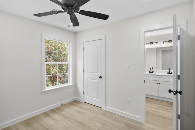 unfurnished bedroom with connected bathroom, ceiling fan, sink, and light hardwood / wood-style floors