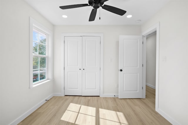 unfurnished bedroom with a closet, light hardwood / wood-style flooring, and ceiling fan