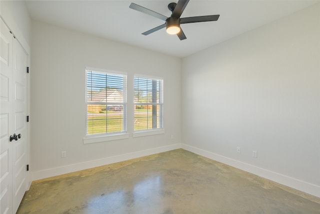 spare room with ceiling fan and concrete floors