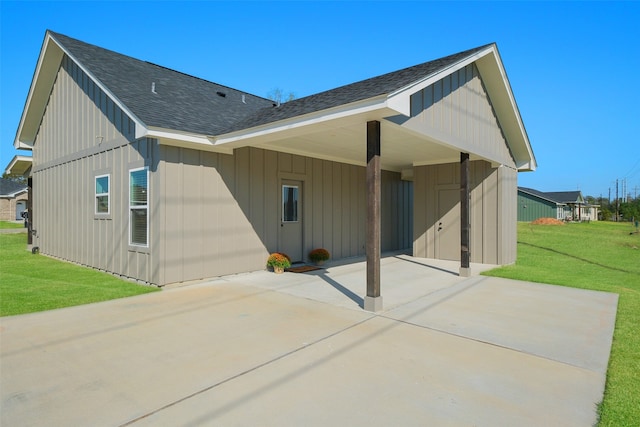 rear view of property with a carport and a lawn