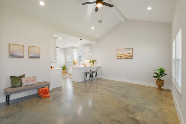 living room featuring vaulted ceiling with beams, concrete flooring, a healthy amount of sunlight, and ceiling fan