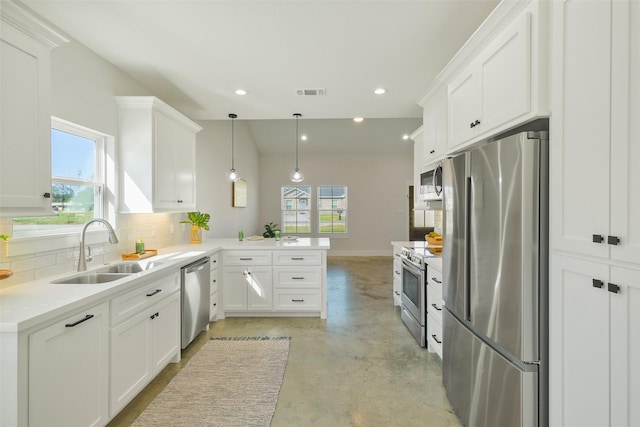 kitchen featuring sink, white cabinetry, hanging light fixtures, stainless steel appliances, and kitchen peninsula