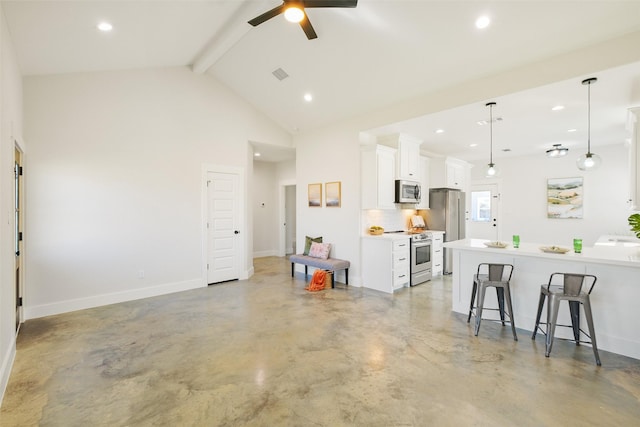 kitchen featuring a breakfast bar, appliances with stainless steel finishes, white cabinetry, decorative light fixtures, and beamed ceiling