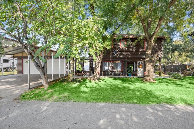 view of front of home featuring a carport, a front yard, and a garage