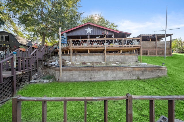 back of property featuring a deck and a lawn