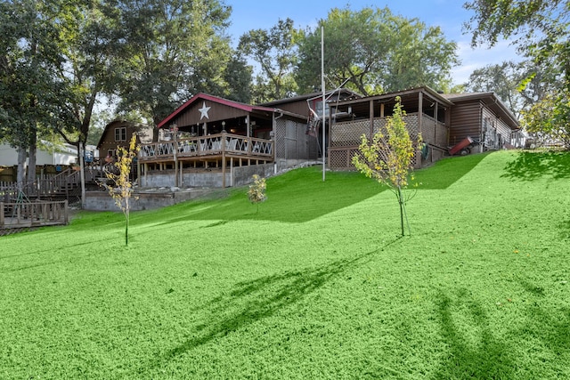 rear view of house with a deck and a lawn