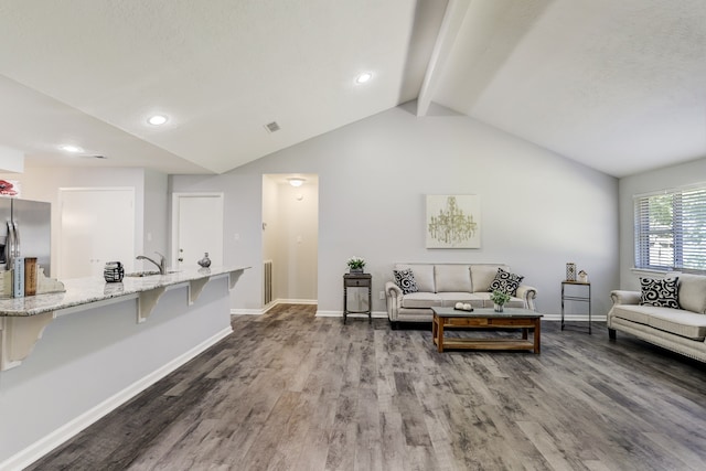 living room with lofted ceiling with beams, sink, and dark hardwood / wood-style flooring