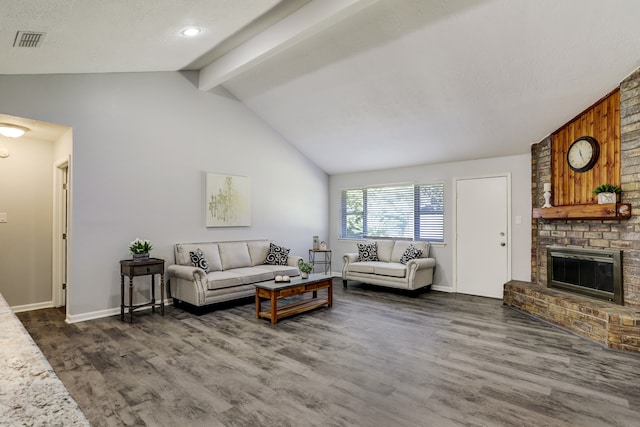 living room with dark hardwood / wood-style floors, lofted ceiling with beams, a textured ceiling, and a fireplace