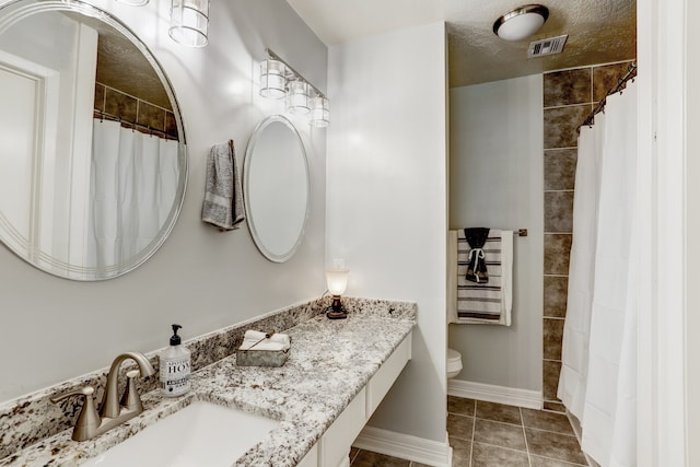 bathroom with tile patterned floors, toilet, a shower with shower curtain, vanity, and a textured ceiling