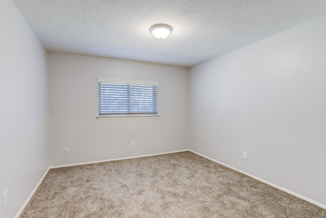 carpeted spare room with a textured ceiling