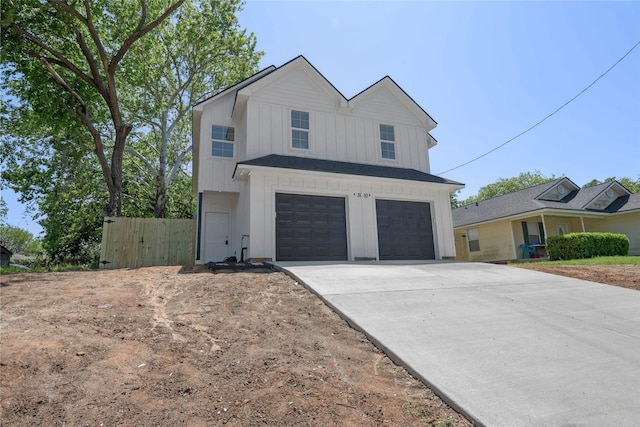 1310 E Alamo St A-B, Unit A-B Brenham, TX 77833 - view of front of house with board and batten siding, driveway, fence, and a garage