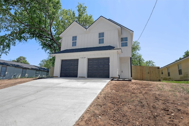1310 E Alamo St A-B, Unit A-B Brenham, TX 77833 - view of front facade featuring an attached garage, board and batten siding, concrete driveway, and fence