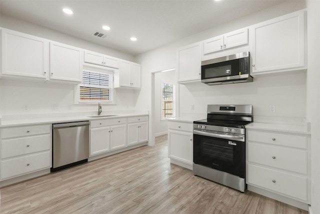 1310 E Alamo St A-B, Unit A-B Brenham, TX 77833 - kitchen with stainless steel appliances, light countertops, white cabinetry, and a sink