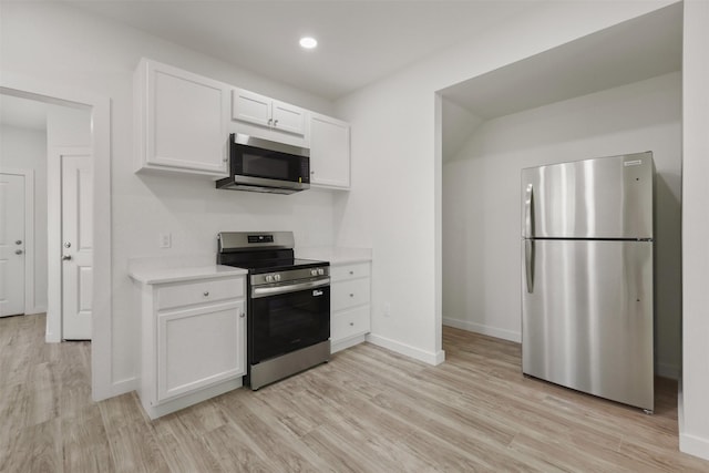 1310 E Alamo St A-B, Unit A-B Brenham, TX 77833 - kitchen with light wood-type flooring, baseboards, light countertops, white cabinets, and appliances with stainless steel finishes