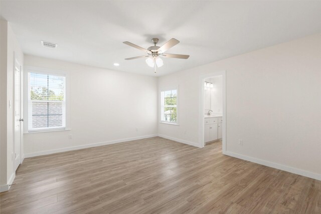 1310 E Alamo St A-B, Unit A-B Brenham, TX 77833 - spare room featuring light wood finished floors, ceiling fan, baseboards, and visible vents