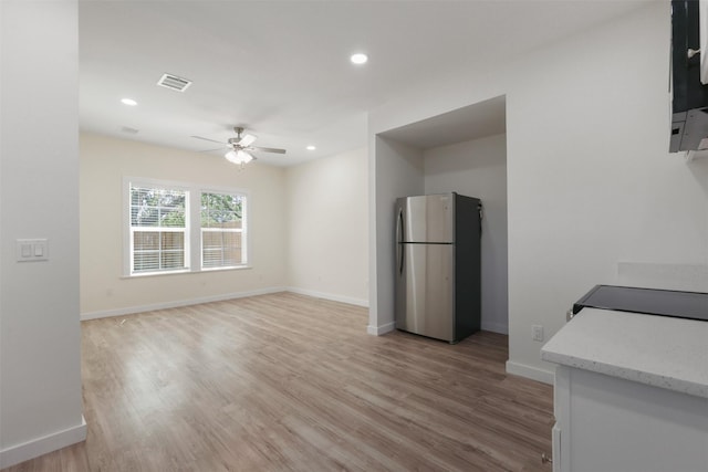 1310 E Alamo St A-B, Unit A-B Brenham, TX 77833 - interior space featuring visible vents, baseboards, freestanding refrigerator, a ceiling fan, and light wood-style flooring