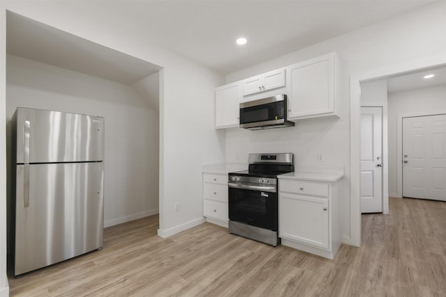 1310 E Alamo St A-B, Unit A-B Brenham, TX 77833 - kitchen featuring baseboards, light countertops, white cabinetry, stainless steel appliances, and light wood finished floors