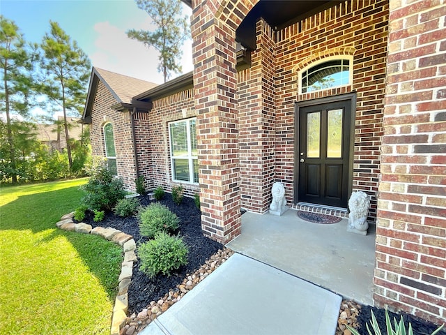 view of exterior entry featuring a yard