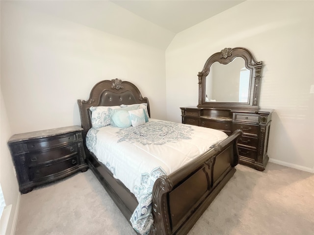 bedroom featuring vaulted ceiling and light colored carpet