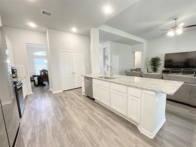 kitchen featuring light hardwood / wood-style floors, a kitchen island with sink, sink, appliances with stainless steel finishes, and white cabinetry