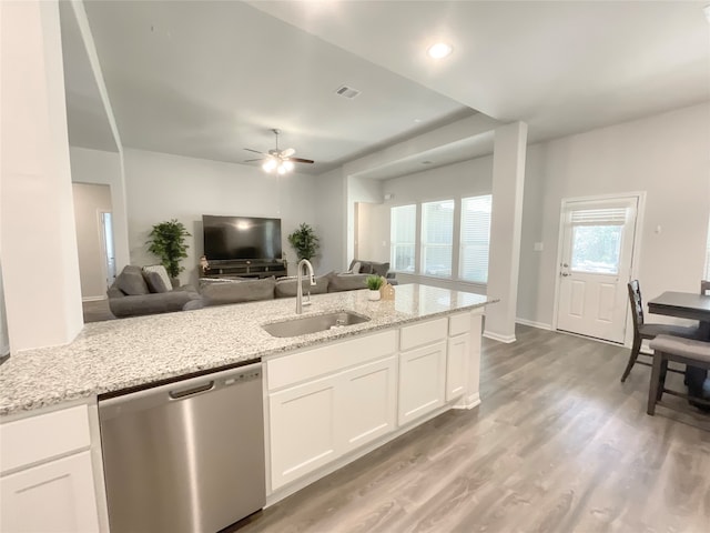 kitchen featuring sink, white cabinetry, stainless steel dishwasher, and light stone countertops