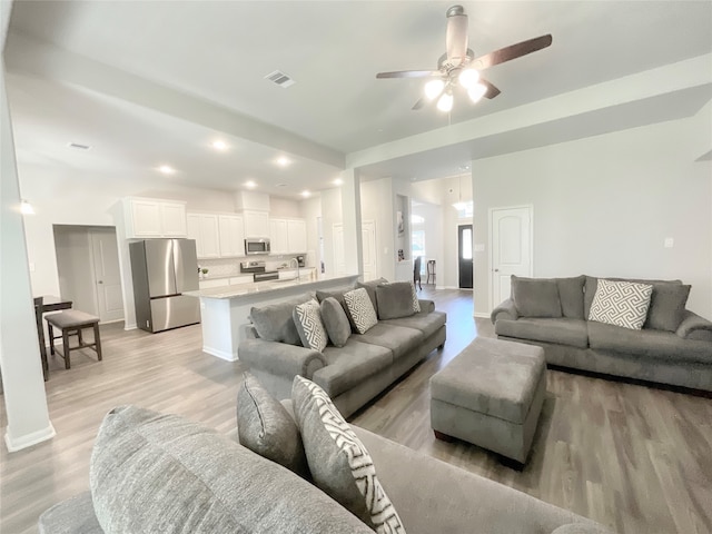 living room with ceiling fan and light hardwood / wood-style floors