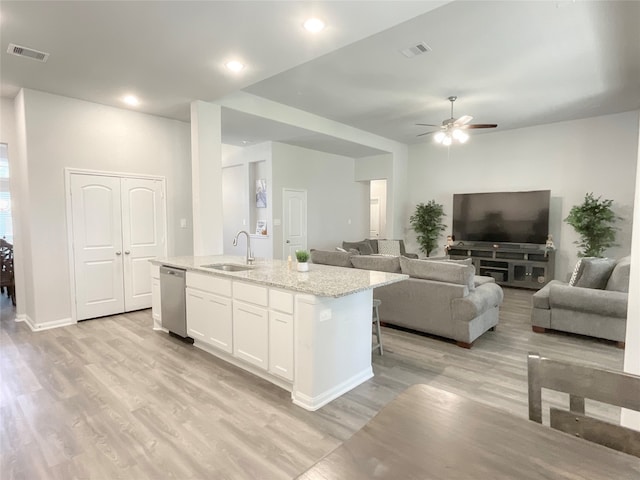 kitchen featuring sink, light hardwood / wood-style flooring, a center island with sink, white cabinetry, and dishwasher