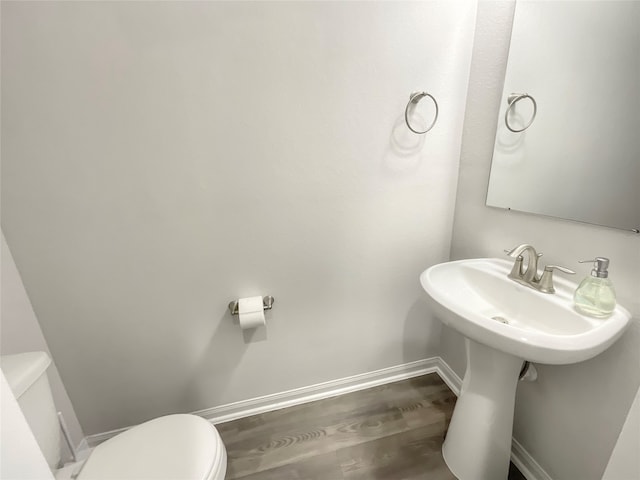 bathroom with hardwood / wood-style floors and toilet